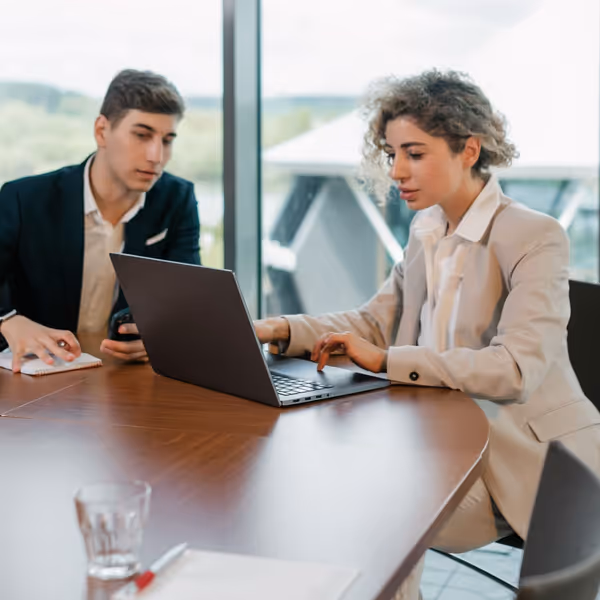Dos profesionales revisando un proyecto digital en un portátil en una oficina moderna